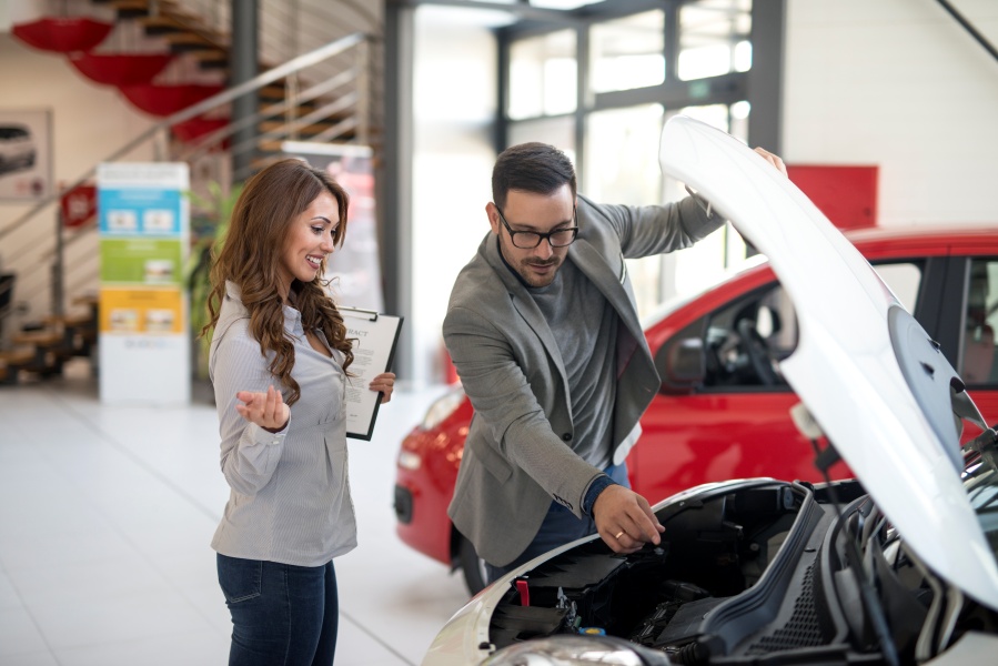 Car dealer presenting vehicle to the buyer.